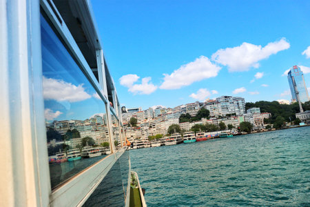 Istanbul, Turkey on 12 July 2022. A ferry boat ride offers a cityscape view across the water under a bright blue sky with fluffy clouds Perfect for travel and urban adventures.のeditorial素材