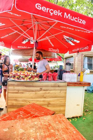 Istanbul, Turkey on 12 July 2022. A man serves colorful fruit salads at a stand outdoors on a summer day, offering a refreshing treat This image is perfect for food or lifestyle content.のeditorial素材