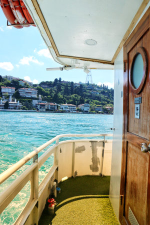 Enjoying a boat ride on a bright day offers scenic views of a hillside with houses near the coast Great for travel and vacation themes.のeditorial素材