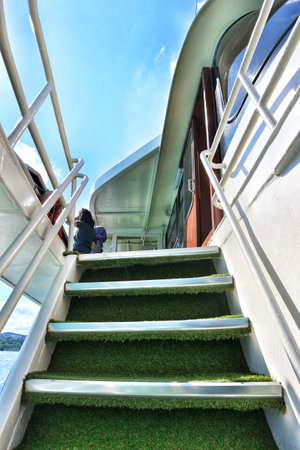 Climbing the stairs on a boat, the steps are lined with artificial turf, providing a unique touch This is suitable for themes like travel and boating.のeditorial素材