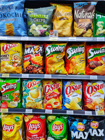 Ho Chi Minh, Vietnam on 11 May 2025. Eye level shot showcases shelves of diverse flavored chips perfect for snacking and convenience store shoppers looking for variety and delicious treat.のeditorial素材