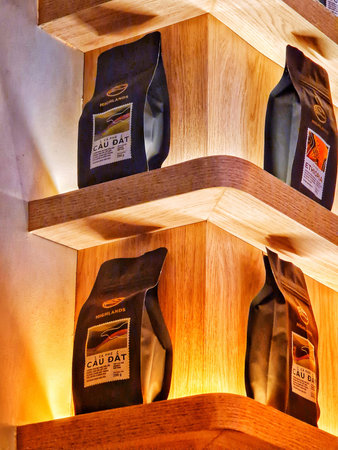 Ho Chi Minh, Vietnam on 11 May 2025. Highland. Coffee bags are arranged on lighted wooden shelves creating a cozy and warm ambiance Ideal for cafe or product photography.のeditorial素材