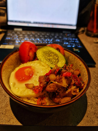 Bekasi, Indonesia 14 Jun 2025. a delicious rice bowl with a fried egg, fresh vegetables, and spicy chili paste ready to eat Perfect for food blogs and culinary content.のeditorial素材