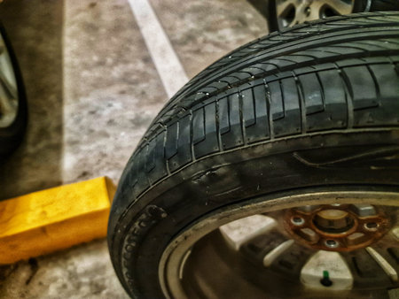 Bekasi, Indonesia on 12 Jun 2025. a car tire mounted on a rim, resting on the ground with line...