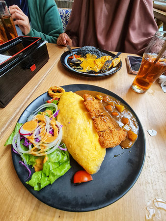 Jakarta, Indonesia on 8 Jun 2025. Overhead shot of a dining table featuring curry dishes and a fresh salad, creating a vibrant and appealing culinary scene Ideal for food and dining related content.のeditorial素材