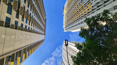 Bekasi, Indonesia on 1 Feb 2024. Three tall modern residential buildings rise towards a clear blue...