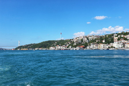 Istanbul, Turkey on 12 July 2022. Bosphorus. Picturesque coastal city extends along green hills by the wavy blue sea with a bridge under a clear sky, creating a tranquil atmosphere perfect for travel and tourism-related content.のeditorial素材