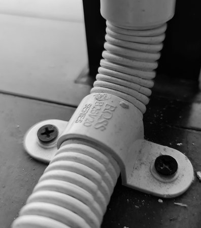 Jakarta, Indonesia on 26 September 2025. Corrugated plastic tube secured with screws creates an industrial, monochromatic closeup image suitable for construction, engineering, or plumbing related content.のeditorial素材