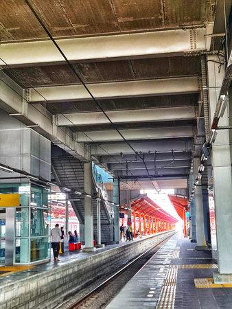 Bekasi, Indonesia on 27 Jun 2025. People are waiting at a train station on a platform with metal columns and an overhead structure, creating a modern and functional scene suitable for transportation or city-themed visuals.のeditorial素材