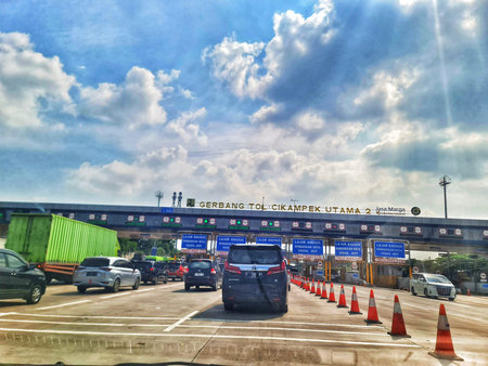 Cikampek, Indonesia on 26 Jun 2025. Vehicles are driving through a toll road entrance under a...