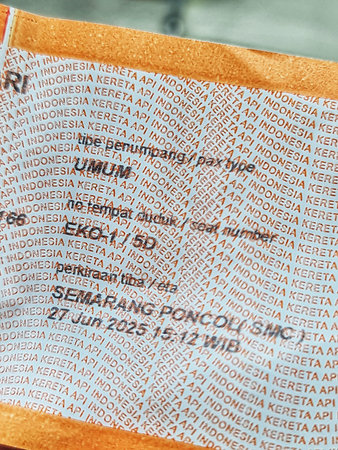 Bekasi, Indonesia on 27 Jun 2025. Close-up shows a textured ticket with repeating Indonesian text, 'KERETA API INDONESIA', creating a pattern on the weathered surface, suitable for travel or typographic designs.のeditorial素材