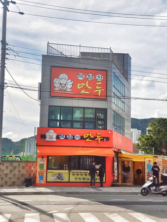 Busan, South Korea on 9 Nov 2024. People gather outside a bright colorful building on a city street...