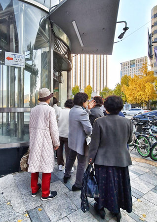Seoul, South Korea on 10 Nov 2024. A group of people queue up outside a building entrance on a city...