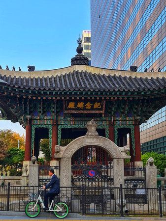 Seoul, South Korea on 10 Nov 2024. A person rides a bicycle past a traditional building with a...