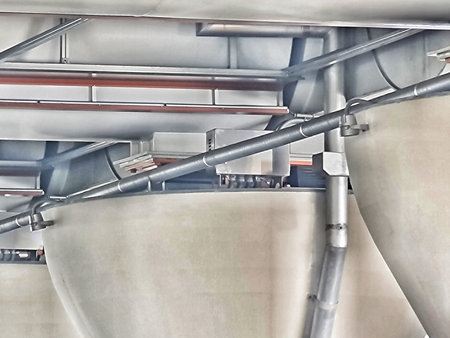 Inside view showcases the complexity of industrial silos connected by a network of pipes,...