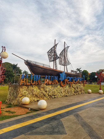 Jepara, Indonesia on 6 Sep 2025. A large ornamental ship sculpture stands prominently in a green park under a cloudy sky, creating a unique landmark suitable for travel and tourism themes.のeditorial素材