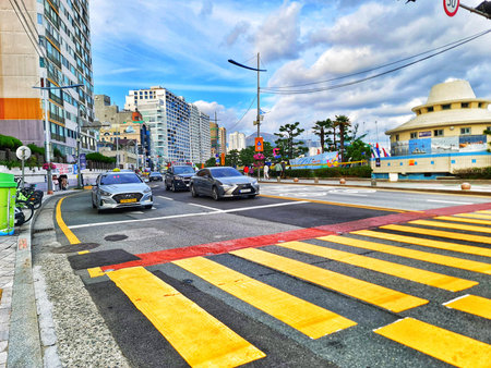 Busan, South Korea on 8 Nov 2024. A city street shows cars moving along the road and a pedestrian...