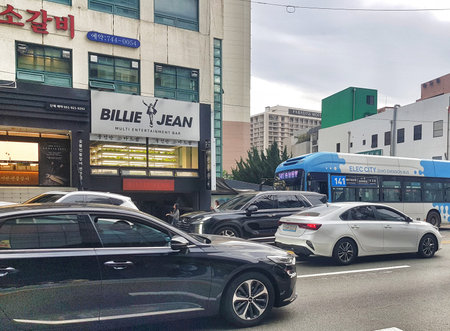 Busan, South Korea on 9 Nov 2024. Busy urban street scene shows passing cars and a blue city bus in...