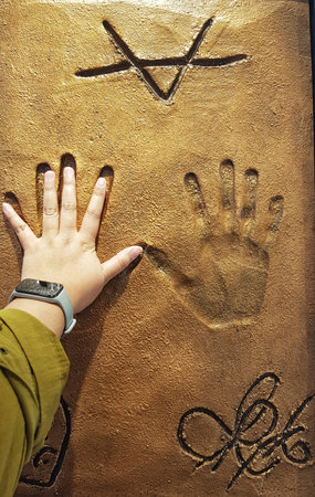 Seoul, South Korea on 12 Nov 2024. V BTS. A child's hand with a gray wristband is touching a...