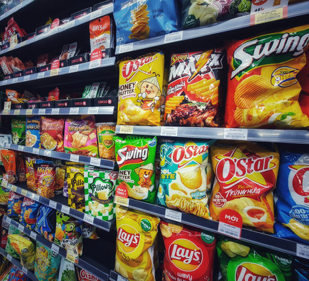Ho Chi Minh, Vietnam on 11 May 2025. Assorted snack packages, including potato chips, line the...