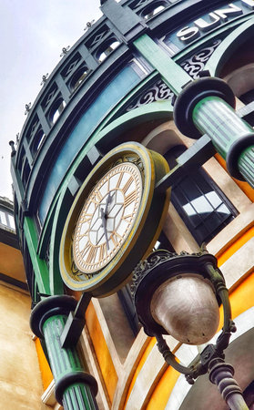 Sa Pa, Vietnam on 15 May 2025. An antique-style clock with roman numerals hangs suspended from decorative green ironwork, beneath a muted streetlamp, creating a vintage and architectural scene perfect for travel and cityscape marketing.のeditorial素材
