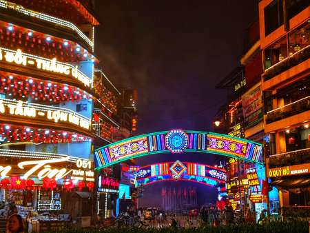 Sa Pa, Vietnam on 15 May 2025. Vibrant archway illuminated with colorful lights spans a bustling city street at night, creating a festive atmosphere and a sense of urban exploration, suitable for travel and city-themed marketing.のeditorial素材