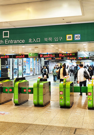 Tokyo, Japan on 12 Oct 2025. Kinshicho Station. People passing through modern green subway gates...