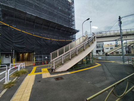 Tokyo, Japan on 12 Oct 2025. Urban stairway stands adjacent to a construction site, featuring gray...
