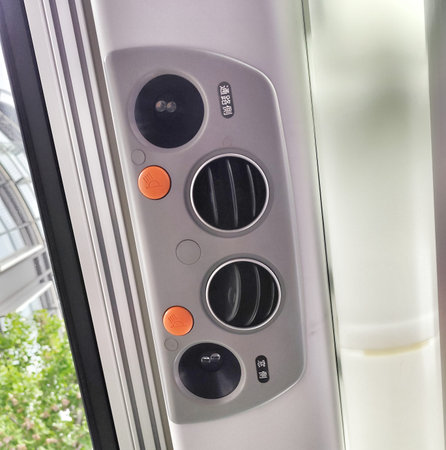 Tokyo, Japan on 12 Oct 2025. Gray control panel in train featuring vents, orange buttons, and...