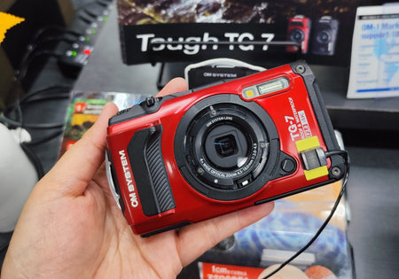 Osaka, Japan on 18 Oct 2025. Hands hold a red compact digital camera in a store, with display and...