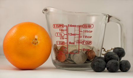 Measuring cup, lemon, grapes