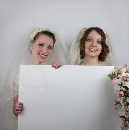 Two young brides holding blank signの写真素材