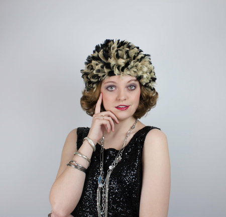 Beautiful young woman wearing vintage feather cap