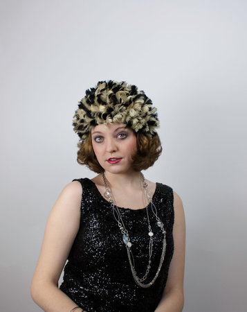 Beautiful young woman wearing vintage feather cap 
