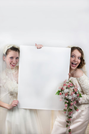 Two young brides holding blank signの写真素材