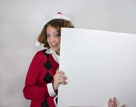 Pretty young woman wearing red and black sweater and Santa hatの写真素材