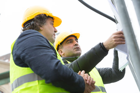 Two construction site managers office about discussing blueprints at construction siteの写真素材