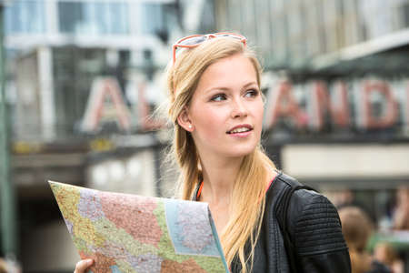 Pretty young female holding a mapの写真素材