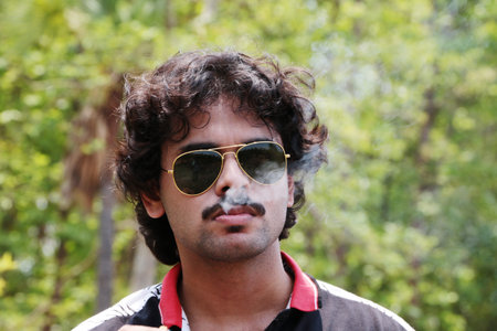 Bengali Handsome young boy with mustache wearing sunglass smoking cigarette