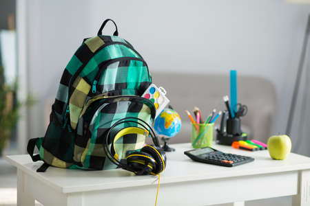 School backpack is in the interior of the apartment. On the desk, stationery and school facilitiesの写真素材