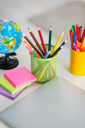 On the desk in the interior of the apartment are stationery items. Multicolored pencils, markers and...