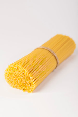 Italian spaghetti tied with a brown thread. Raw paste on an empty backgroundの写真素材