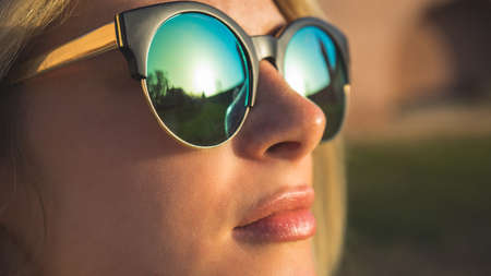 Close-up face portrait of young beautiful woman with perfect skin in round sunglassesの写真素材