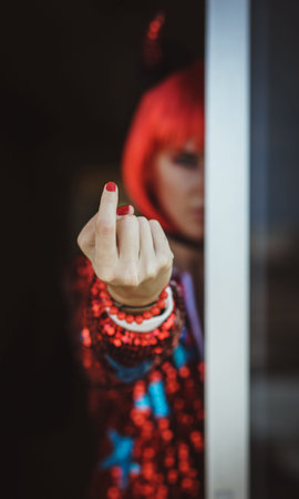 The devil girl beckons the viewer to itself. Fingers with red nails. The bokeh effect. Mysterious...