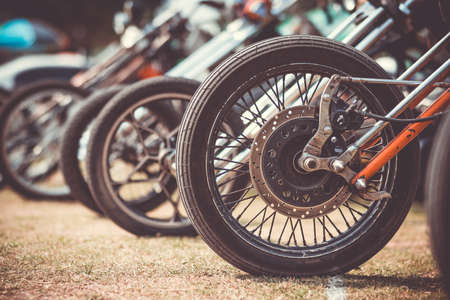 Front wheels of motorcycles exposed in a parking lotの写真素材
