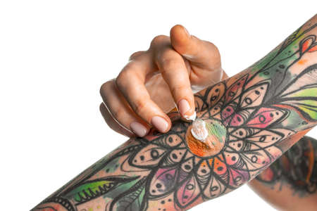 Fingers apply cream to skin. Close upの写真素材