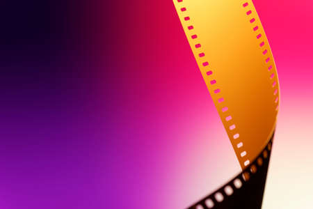 Camera negative camera. Selective focus on film perforation. Unprocessed color motion picture film. Industry symbol for shooting process, photochemical laboratory process and film archive technology. Color gradient background.の写真素材