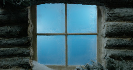 Frosted, snow-covered log cabin window backgroundの写真素材