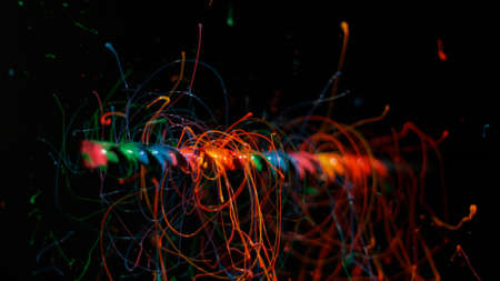 Rainbow paint splatters off of rotating rodの写真素材