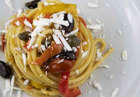 Bucatini with peppers, capers, olives and cherry tomatoesの写真素材